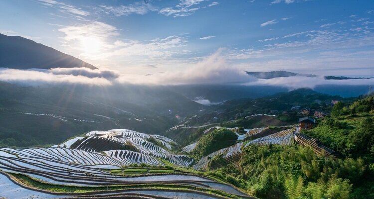 Mirror-like reflections in the Longji Rice Terraces at sunrise